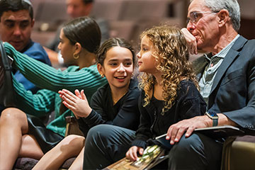 Children sitting in a congregation next to adults. Links to Donor-Advised Funds