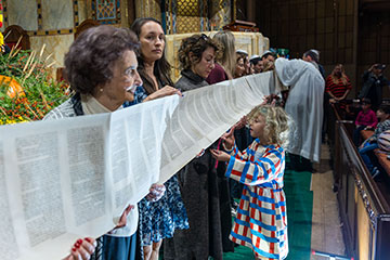 A line of people hold a long scroll of scripture. Links to Gifts of Appreciated Securities