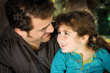 A little girl smiles at her father. Links to Gifts of Life Insurance