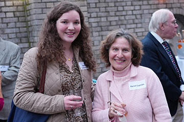 Two women stand outside and smile together. Links to Under Age 60 Two women stand outside and smile together. Links to Under Age 60