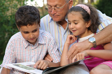 A man reading to his grandchildren. Links to Tangible Personal Property