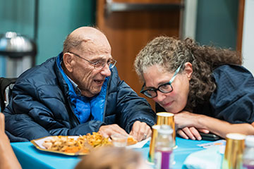 A woman leans in to listen to the words of an elderly man. Links to Over Age 70 A woman leans in to listen to the words of an elderly man. Links to Over Age 70